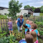 teaching kids in garden at summer camp