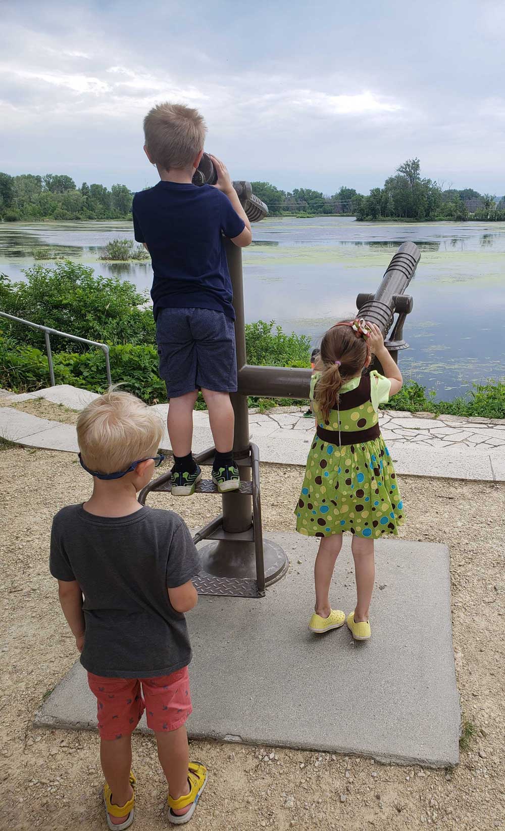 kids taking turns looking through telescope over pobd