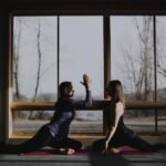 2 women high-fiving during yoga
