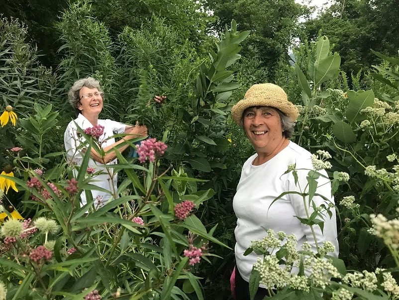 Volunteers, Betty and Rosalie, having fun in the Retention basin garden.
