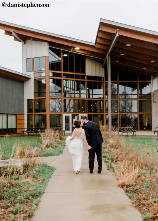 bride and groom walking in to nature center