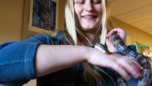 Emma Ehlers, Community Programs Assistant holds The Nature Place's snake, Humphry.