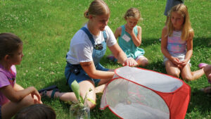 Emma Ehlers, Environmental Educator, releasing a monarch butterfly with summer day campers.