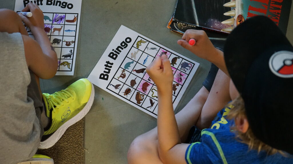 Two boys filling out a butt bingo sheet.