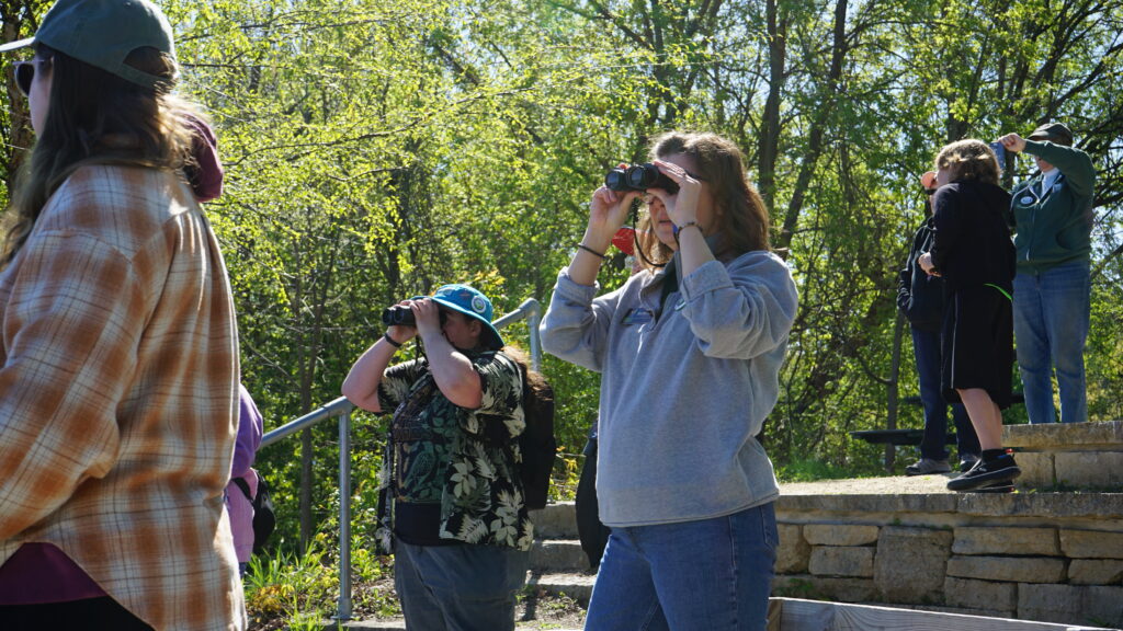 A group of people looking out of binoculars.
