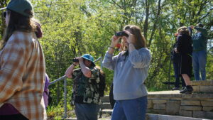 A group of people looking through binoculars.