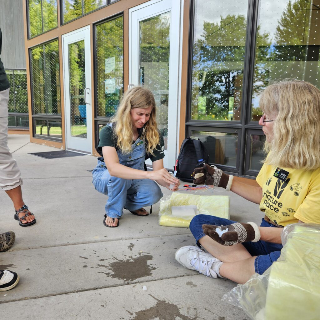 An AmeriCorps Environmental Educator conducting a water experiment.