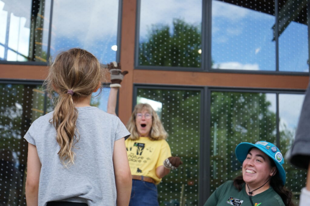The Nature Place Staff and AmeriCorps Environmental Educator celebrate a completed science experiment done by a camper.