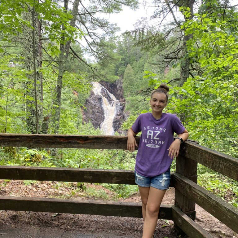 Rayna Torgerson standing in front of a waterfall.